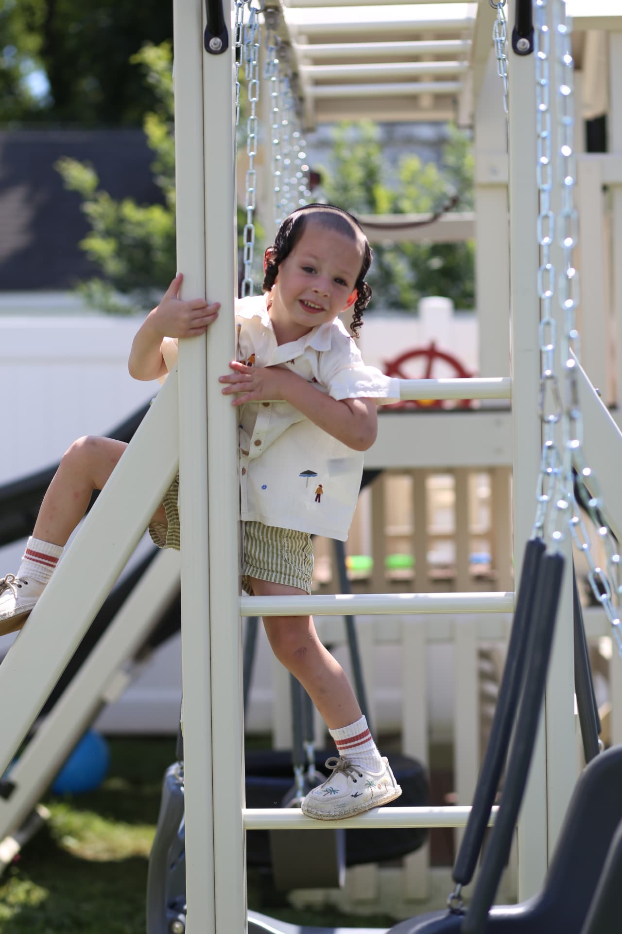 A girl peeking around a playset post.