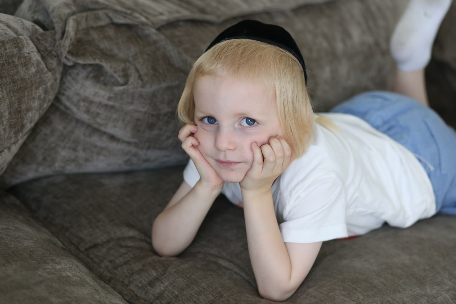 Chin in hands, stretched out on the couch.