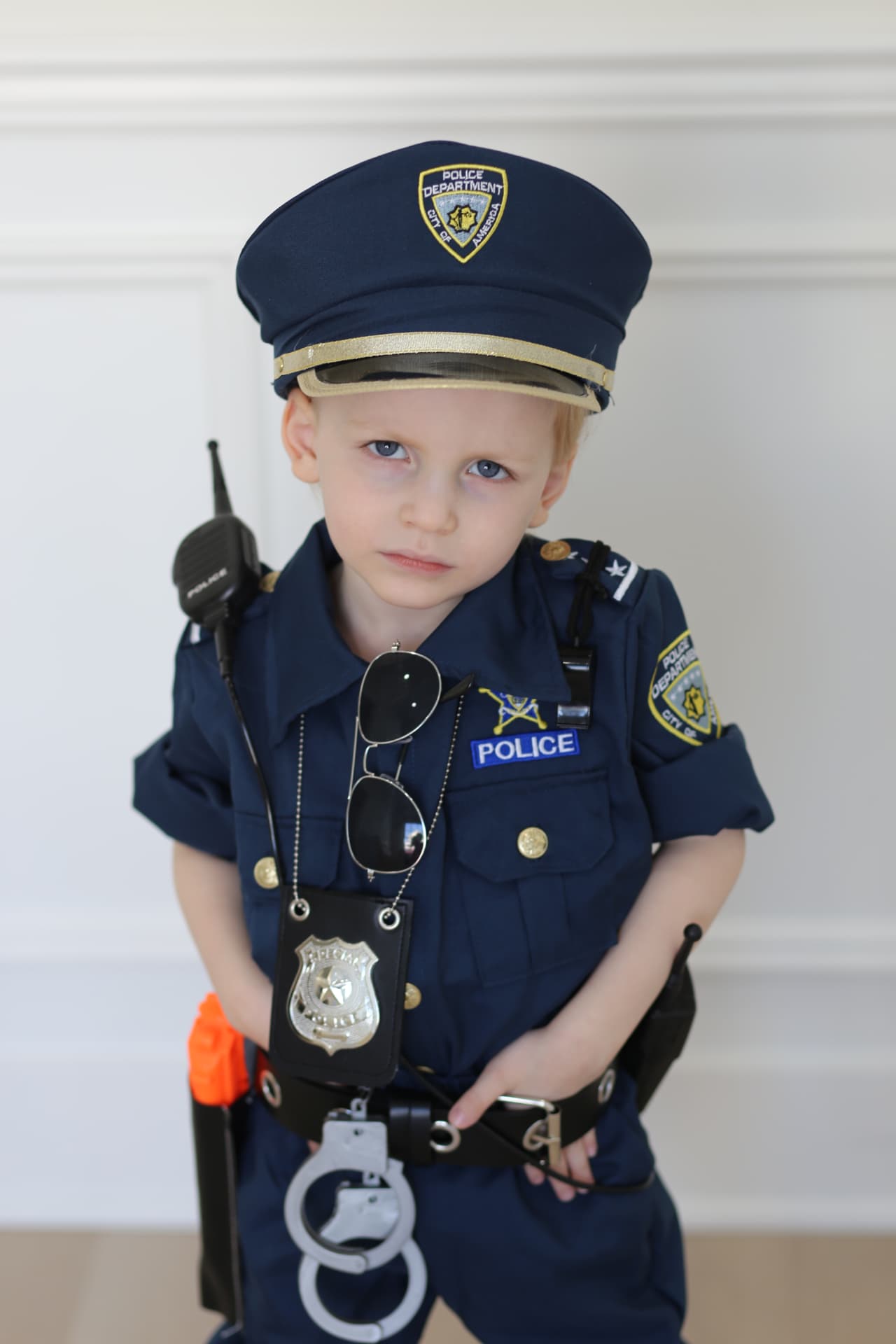 Badge and handcuffs, thumbs tucked in his belt.
