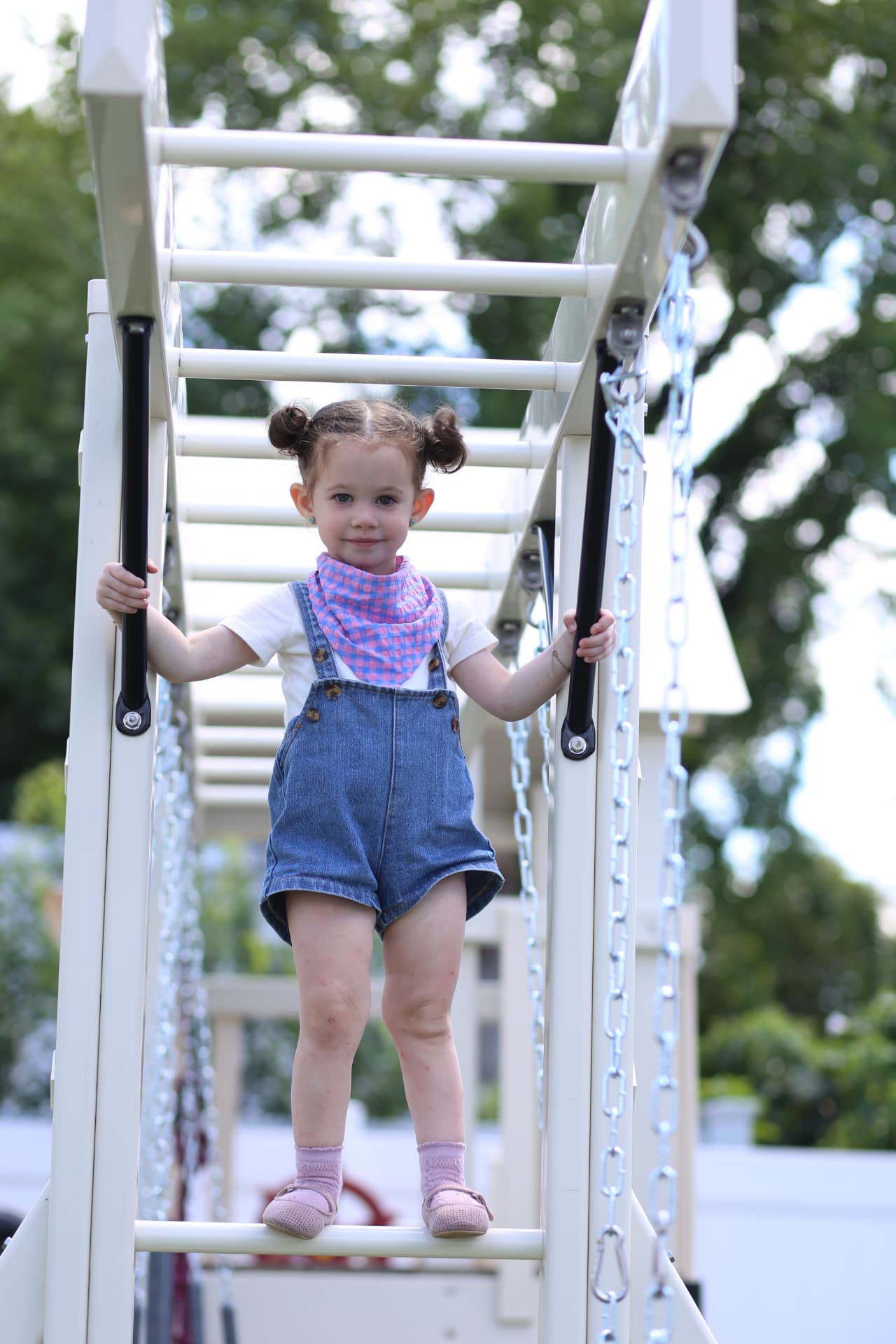 A toddler stepping carefully down a ladder.