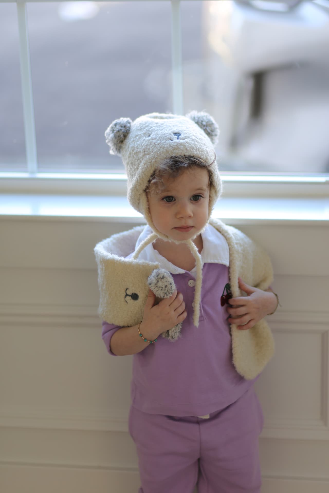 A fuzzy bear hat and a book held close.