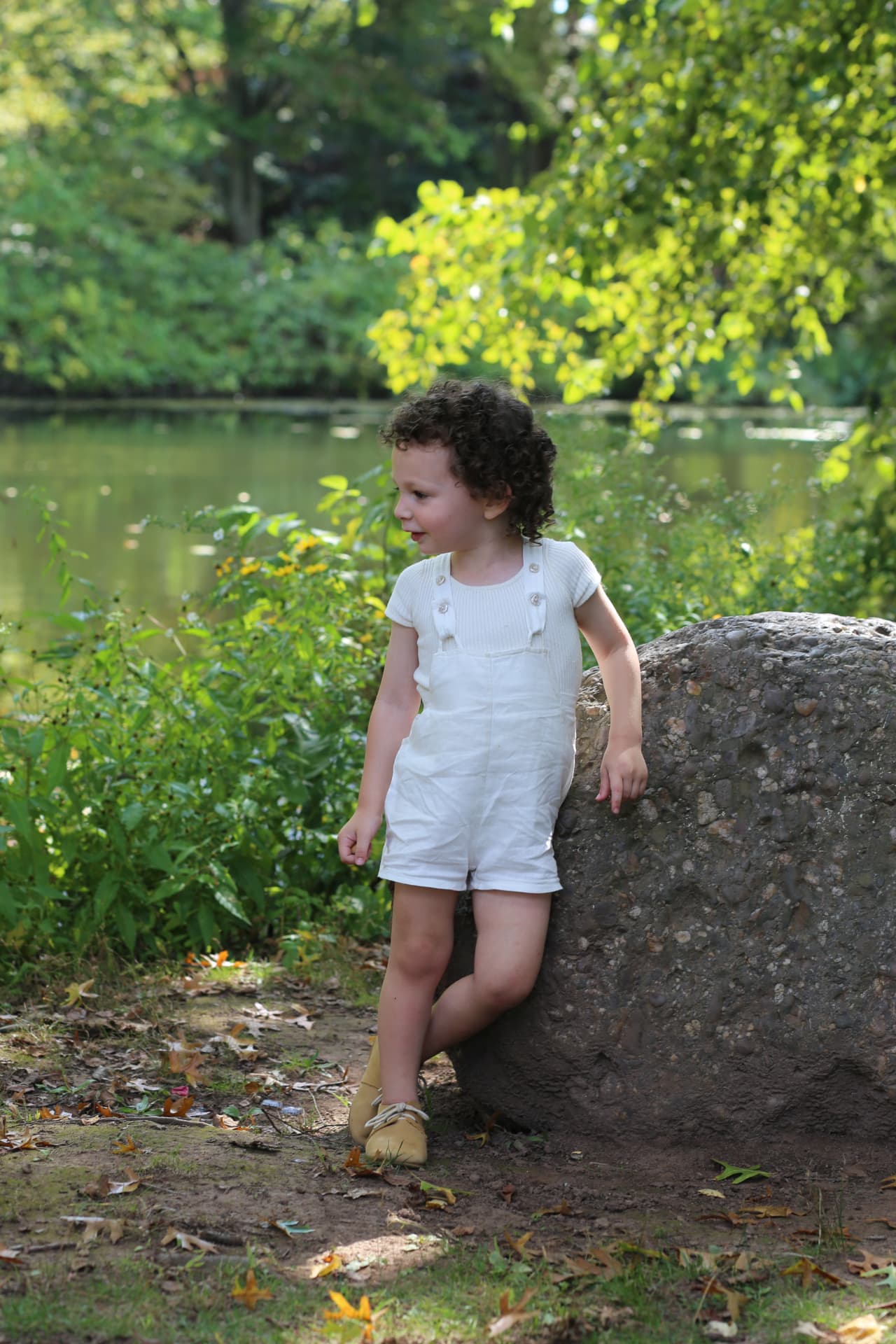 Curls, sunshine, and a big rock to lean on.