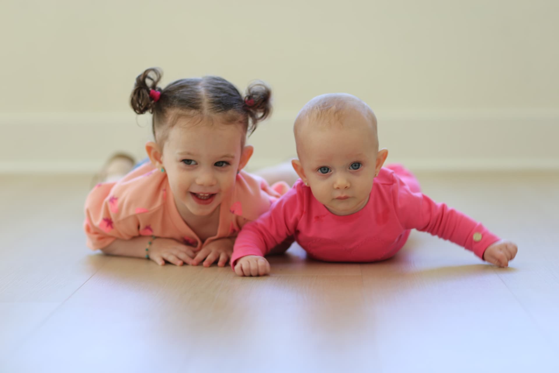 Sister and baby, flat on the floor together.