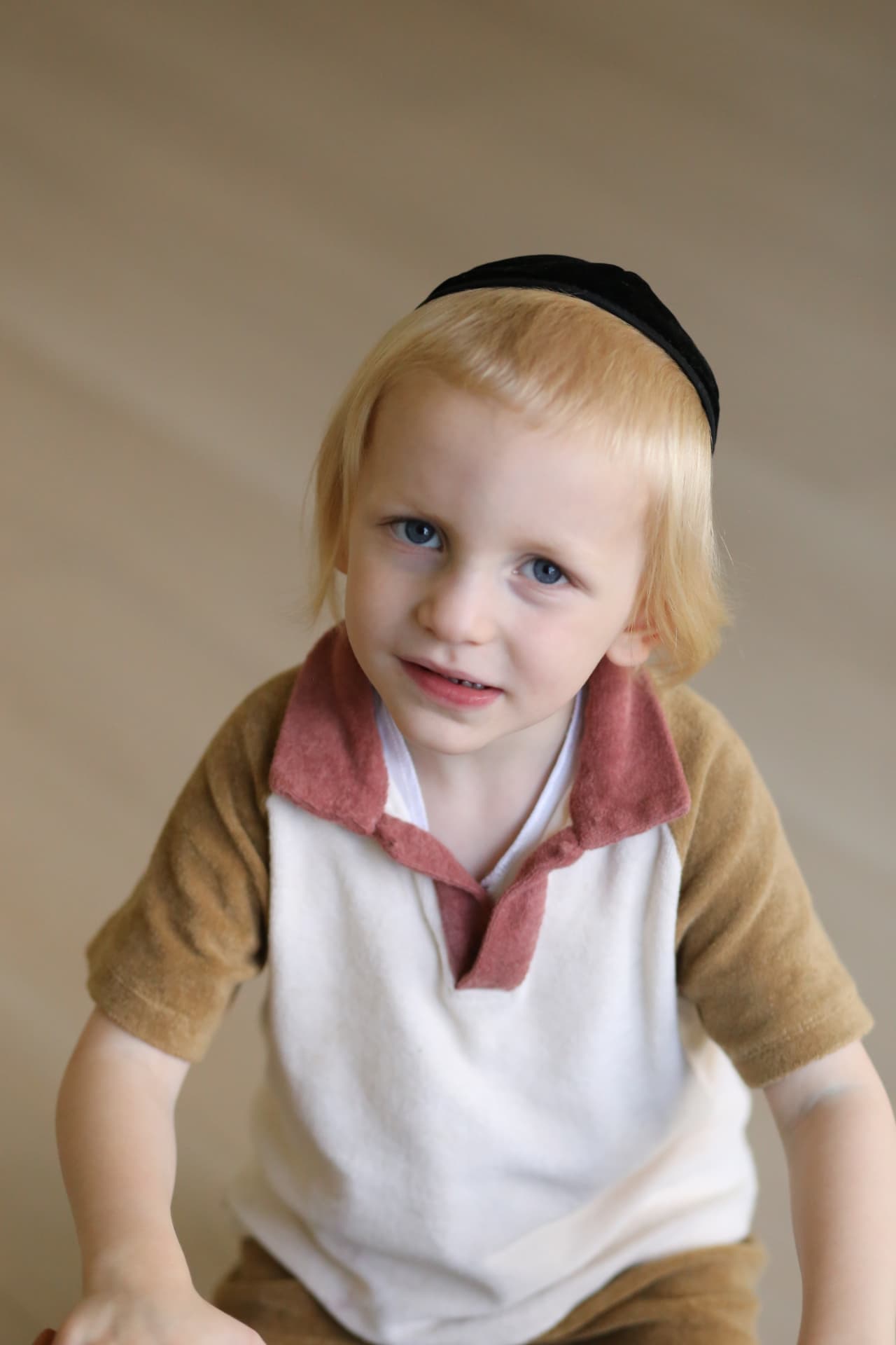A boy in a collared shirt, looking right at us.
