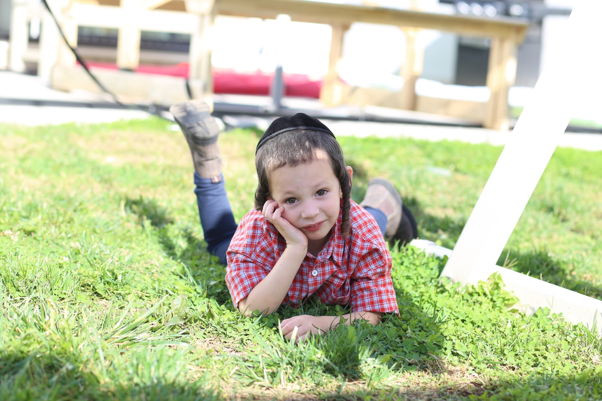 Chin in hand, feet up, in the backyard.