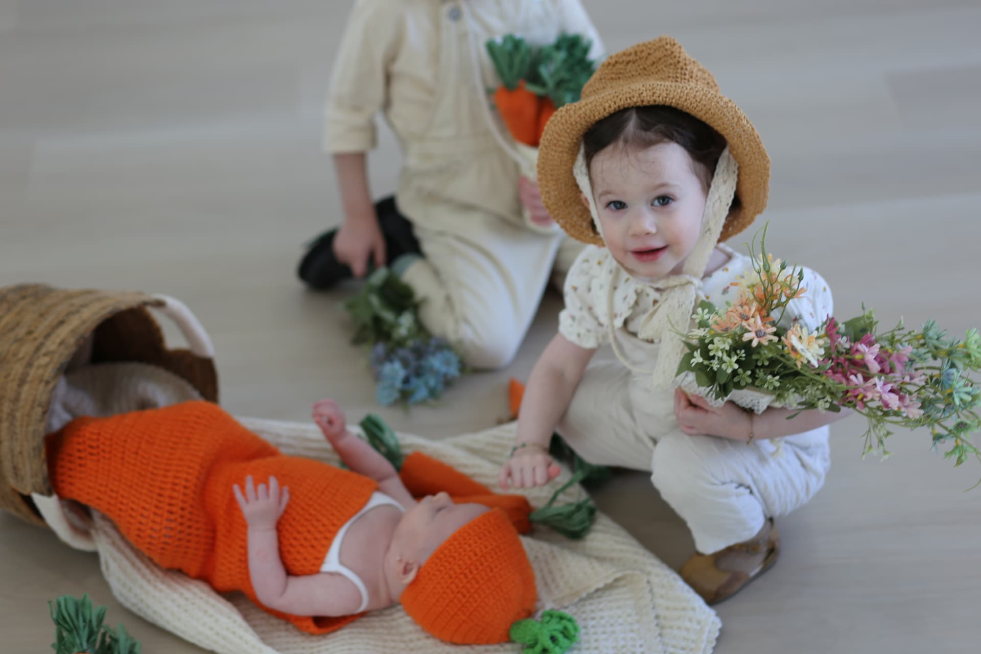 Sister in her straw hat, baby asleep beside her.