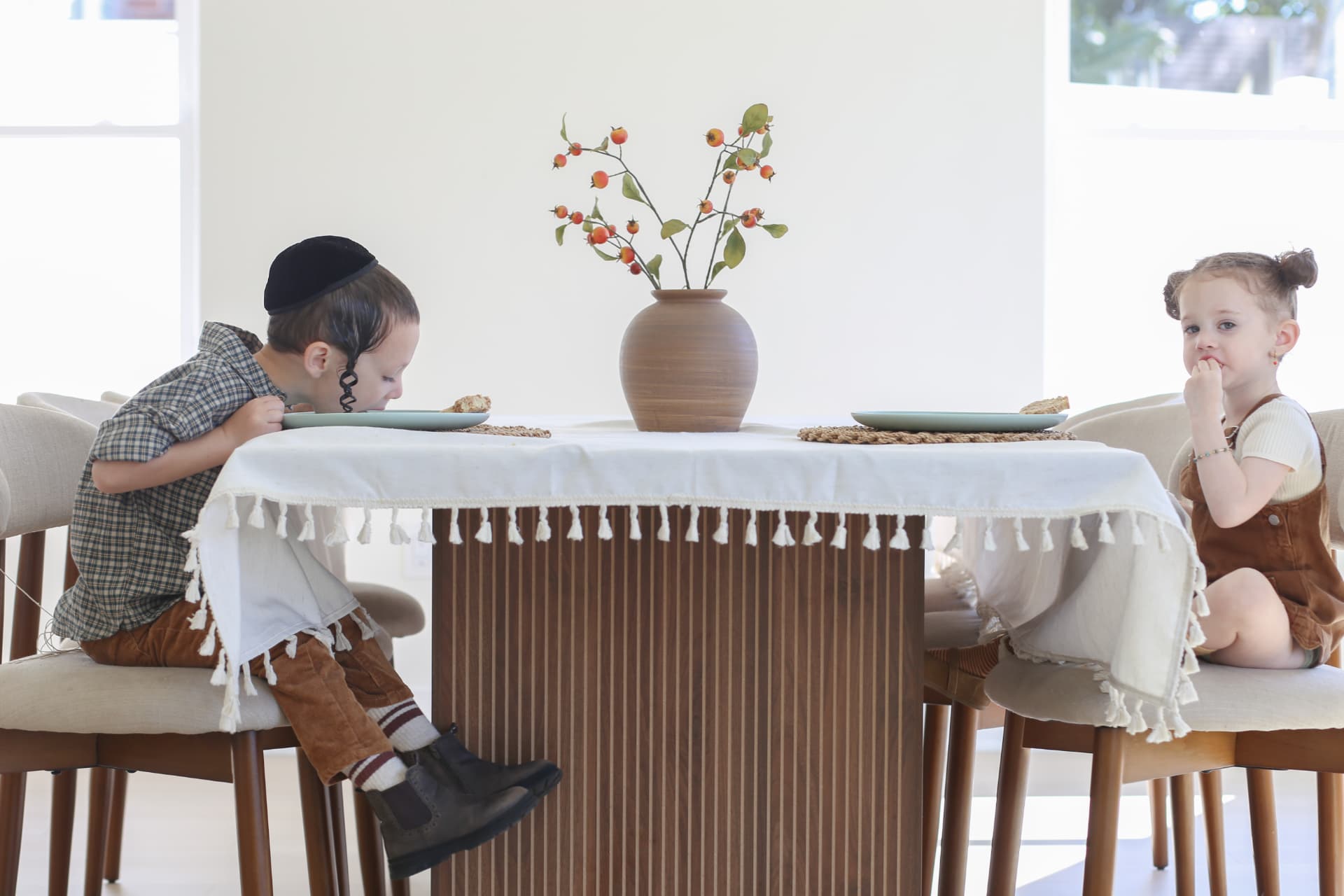 Leaning in across the tablecloth.