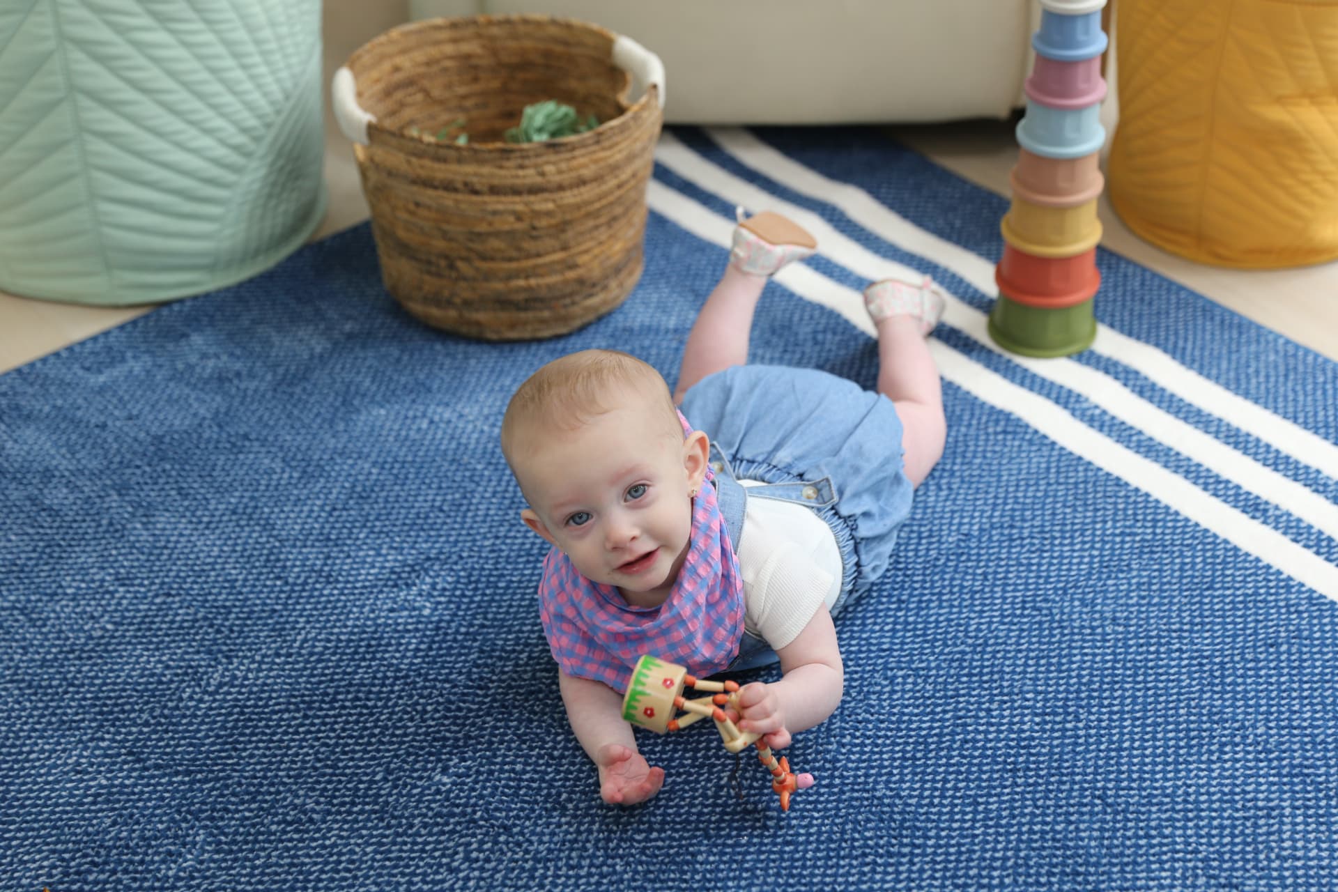 A baby on her tummy, toys all around.