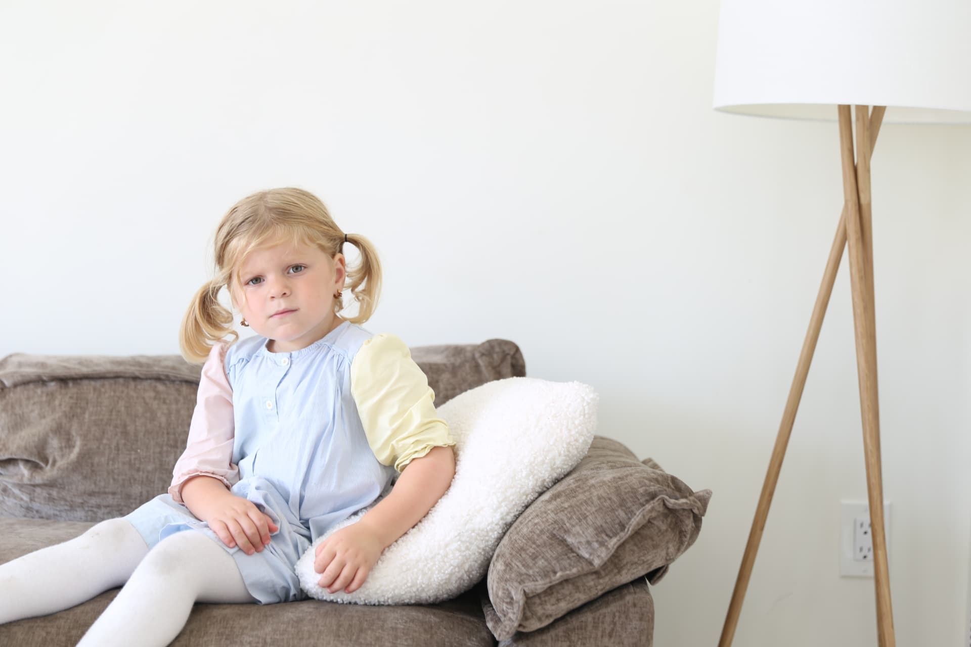 Pigtails and pastels, settled on the couch.