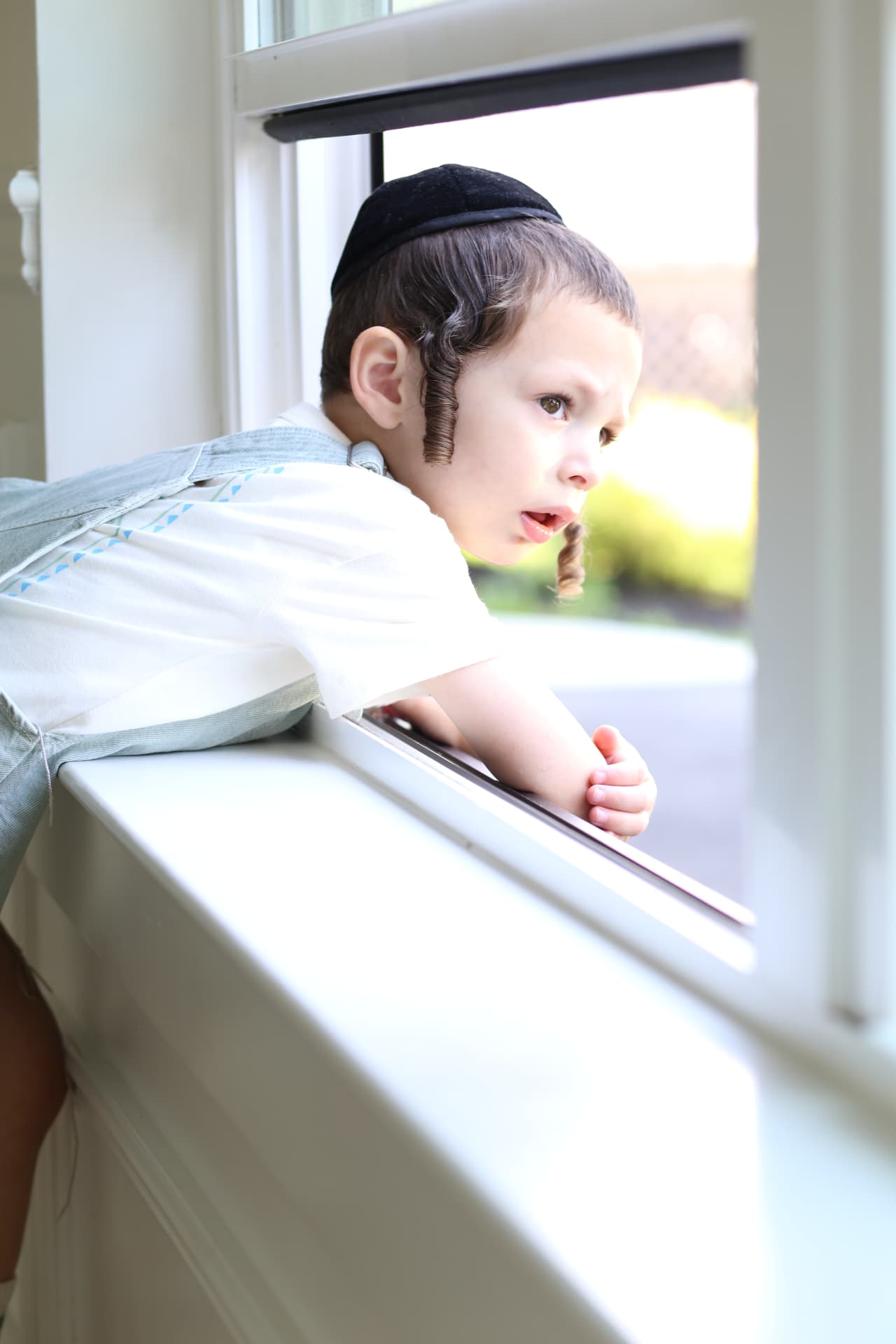 Leaning on the windowsill, watching outside.