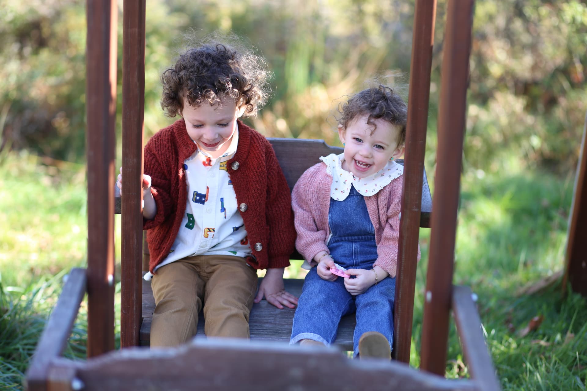 Brother and sister sharing the swing.