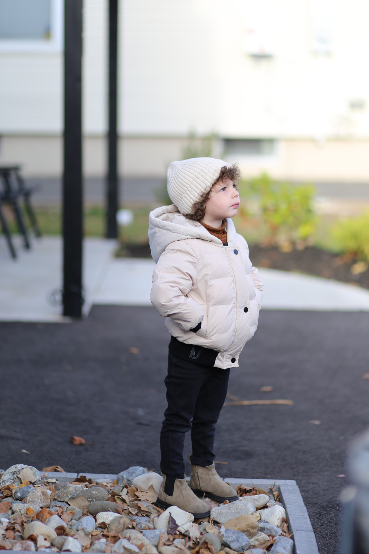 Puffy coat on, looking up at the sky.