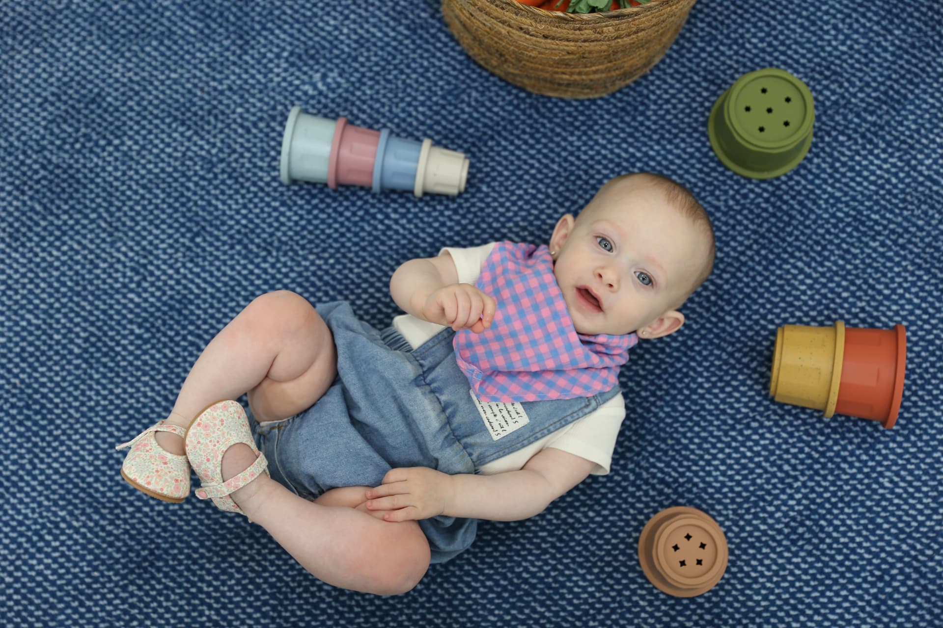 A baby on his back, cups rolling around him.