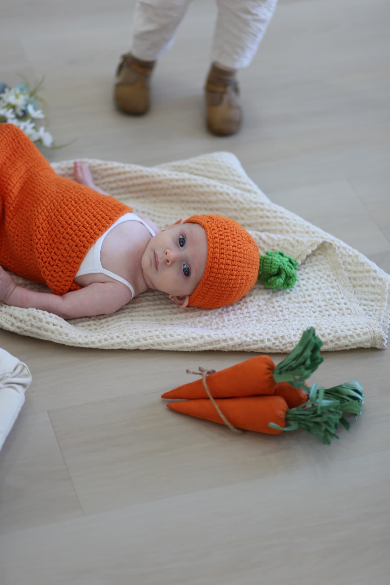 The baby, tucked into a knit carrot hat.