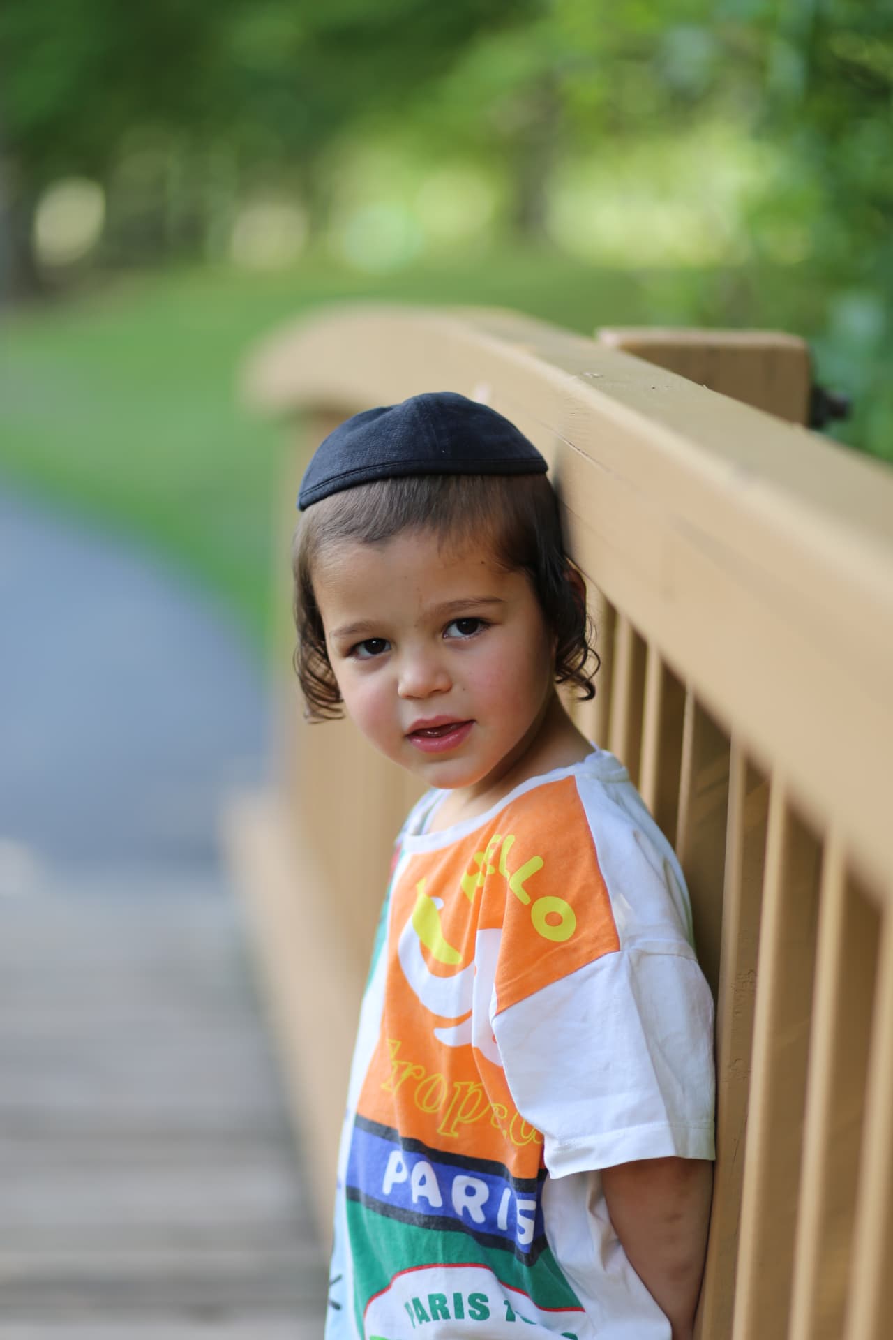 A boy beside the wooden railing.